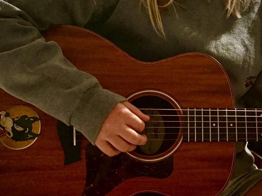 The author strums her acoustic.