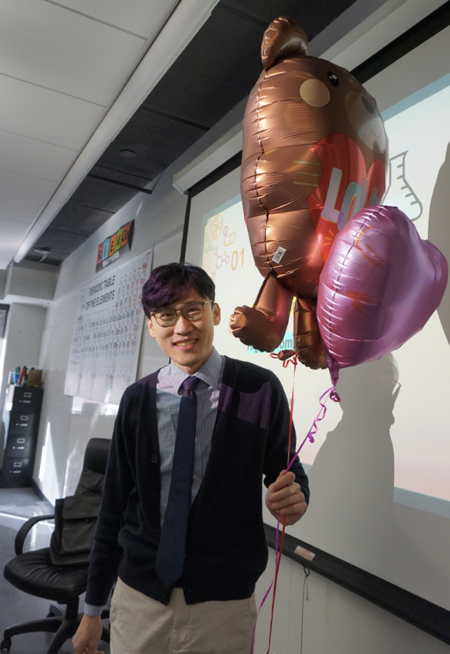 SHC Teacher Mr. Shen holds Valentine’s Day balloons.