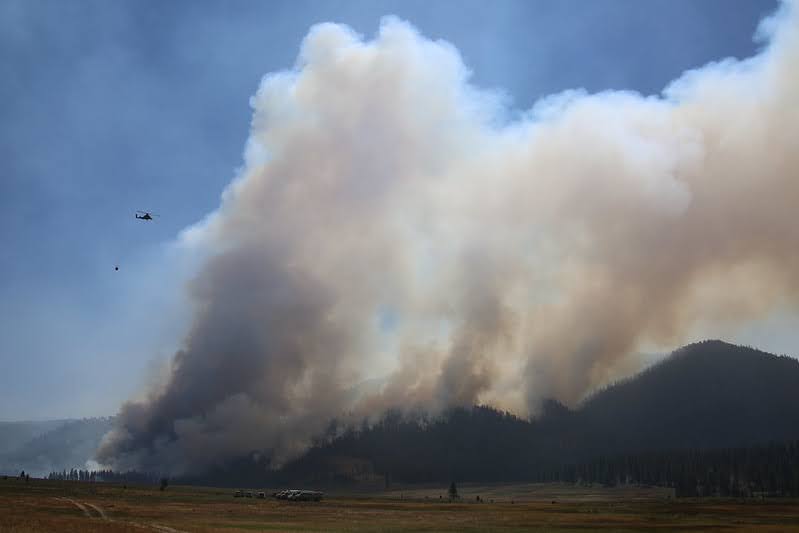Creative Commons picture of the 2020 California wildfires as smoke billows from the hills by Charity Parks.
